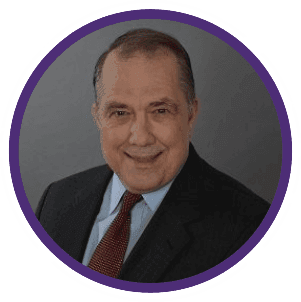 Smiling man in a suit and tie against a gray background, framed by a purple circle.